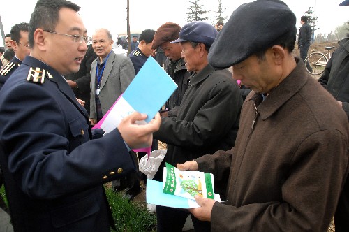 3月22日,在山東省臨沂市河?xùn)|區(qū),臨沂市質(zhì)量技術(shù)監(jiān)督局的工作人員把化肥使用指導(dǎo)手冊送到農(nóng)民手中。新華社記者 徐速繪 攝