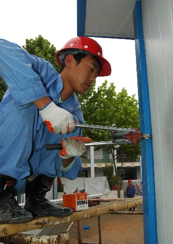 八冶建設集團有限公司的一名工人正在隴南市武都區(qū)城關中學活動板房建設場地施工(6月7日攝)。 目前,支援甘肅隴南災區(qū)的各建筑單位都在緊張施工,力爭更快地將合格的活動板房交給災民。 新華社記者 宋常青 攝