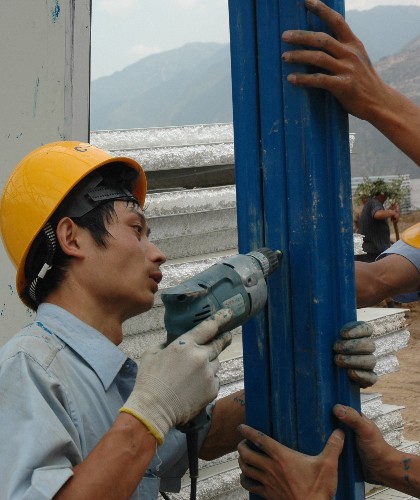 6月8日,中國建筑第二工程局有限公司的工人正在隴南市武都區(qū)東江居民安置點活動板房建設場地施工。 目前,支援甘肅隴南災區(qū)的各建筑單位都在緊張施工,力爭更快地將合格的活動板房交給災民。 新華社記者 宋常青 攝