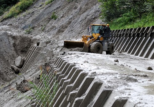 9月2日,武警部隊的工程車輛在川藏公路102道班段清理因泥石流而無法通行的路面。 因近期連續(xù)降雨,川藏公路沿線近日發(fā)生多處泥石流和塌方,嚴重影響交通運輸。其中8月30日下午發(fā)生在西藏自治區(qū)波密縣排龍溝段的大規(guī)模塌方更是使這條公路陷于中斷,大量車輛滯留兩端。經(jīng)武警官兵在排龍溝不分晝夜的搶修,一條近200米長的便道已初步成型。據(jù)了解,如果9月2日晚間當?shù)夭幌掠?,這條便道9月3日就可以投入使用,這就意味著川藏公路有望于9月3日恢復通車。 新華社記者 姜帆 攝