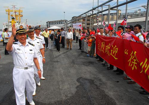 12月6日,在馬來(lái)西亞雪蘭莪州巴生港,中國(guó)海軍“徐州”號(hào)導(dǎo)彈護(hù)衛(wèi)艦上的指揮官向歡迎群眾致意。新華社記者 熊平攝