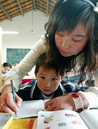 11月13日,上海市浦東新區(qū)大別山小學(xué)一名老師在教學(xué)生寫字。 新華社記者鄭悅攝
