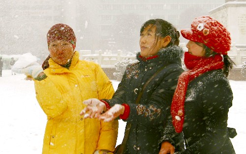 邊城迎飛雪 12月8日,幾位烏魯木齊市民在人民廣場(chǎng)享受雪趣。 當(dāng)日,2007年第二場(chǎng)冬雪降臨邊城烏魯木齊。紛飛飄揚(yáng)的雪花,不僅凈化了空氣,還給人們?cè)鎏砹瞬簧傺┤ぁ?新華社記者王菲攝