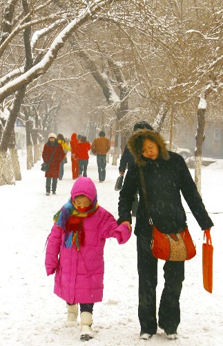12月8日,市民在烏魯木齊市光明路上行走。