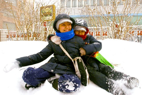 12月8日,兩名小朋友在雪地上玩耍。