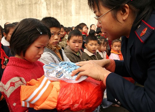 12月12日,四川省華鎣市國稅局的職工向永興小學(xué)的貧困留守兒童贈送新衣、新鞋。