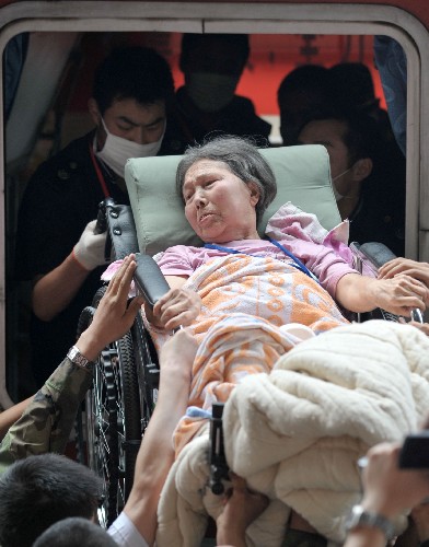 5月23日,在四川綿陽火車站,人們將傷員抬上專列。