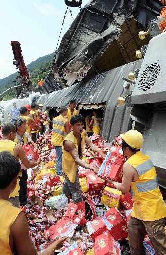 6月8日,成都鐵路局的搶修人員正在達成鐵路上清理脫軌車體內(nèi)的物品。