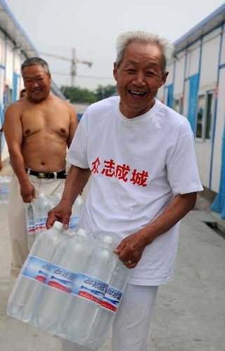6月12日,剛剛?cè)胱∷拇ㄊ《冀呤?#8220;幸福家園”板房區(qū)的78歲老人陳中術(shù)領(lǐng)取免費(fèi)飲用水。