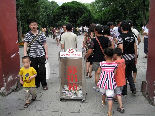6月15日,游人從設置在景區(qū)入口處的募捐箱旁邊經(jīng)過。