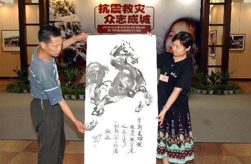 6月16日,退休工人孫繼剛(左)為展覽送來自己創(chuàng)作的畫,表達(dá)對展覽的支持與感動。