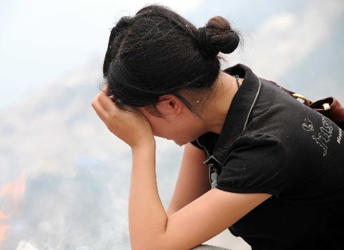 6月29日,一位女士在北川縣城邊的高地上追思親人。