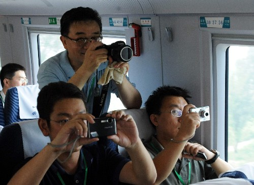 7月24日,乘客在高速列車上拍照。