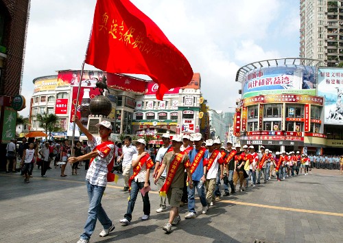 8月1日,廣州市荔灣區(qū)的奧運(yùn)安保志愿者行動隊在上下九商業(yè)區(qū)中前行。