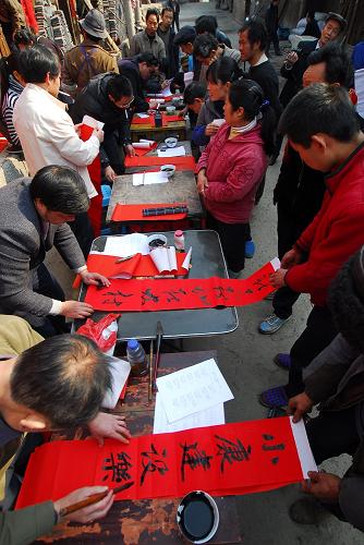 1月17日,書法愛好者們在為苗族村民寫春聯(lián)。當(dāng)日,貴州省丹寨縣的書法愛好者來到石橋村給當(dāng)?shù)氐拇迕袼痛郝?lián)。書法愛好者們共為村民義務(wù)書寫了600余副春聯(lián),給苗族群眾送上一份新春的賀禮。 新華社發(fā)(黃曉海 攝)