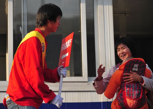 2月2日,志愿者在廣東省汽車站門口導(dǎo)乘。新華社記者 盧漢欣 攝