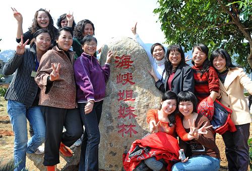 3月12日,海峽兩岸姐妹在古槐百福公園“海峽姐妹林”紀念碑前合影。新華社記者張國俊攝