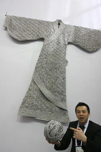 3月19日,參展商介紹一件用舊報紙編織的漢服。新華社發(fā)(陳曉根 攝)