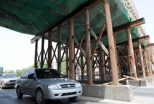 7月23日,車輛從喀和鐵路疏勒縣在建的立交橋下駛過。新華社記者 周文杰 攝