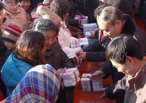 12月4日,司法干部(右)將法律宣傳書籍贈送給農(nóng)民群眾。 新華社記者 尹炣 攝