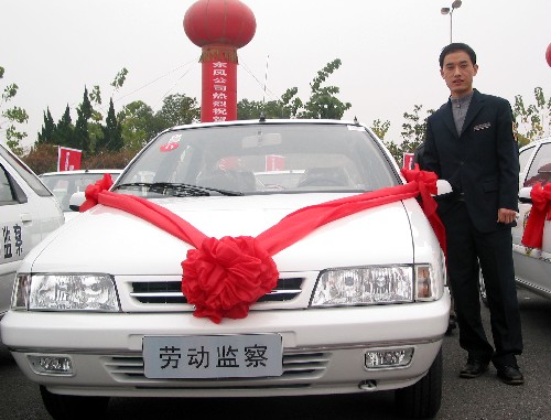 12月26日,一位勞動(dòng)保障監(jiān)察人員站在剛剛配發(fā)的執(zhí)法專用車旁?!⌒氯A社記者 皮曙初 攝