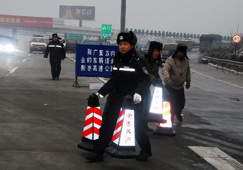 2月1日,湖南省交警總隊副總隊長、高速公路管理支隊支隊長楊能(前)在疏導(dǎo)車輛分流。他在高速公路上已經(jīng)連續(xù)工作了19天。 新華社發(fā)(章堯 攝)
