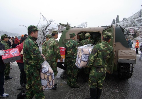 2月3日,解放軍裝甲車開到連州市西江鎮(zhèn)高山村,為被冰雪圍困多日的群眾送來救援物資。當天,廣州軍區(qū)某部緊急派出兩輛裝甲車協(xié)助連州市將大米、棉被等救援物資送到連州市偏遠山村的被困群眾手中。1月24日起,廣東省連州市部分高寒山區(qū)雨雪冰凍天氣加劇,一些鄉(xiāng)鎮(zhèn)道路受阻,出現(xiàn)斷電。連州市政府迅速調(diào)集、運送救援物資,解決被困群眾的生活問題。 新華社發(fā)(曹菁 攝)