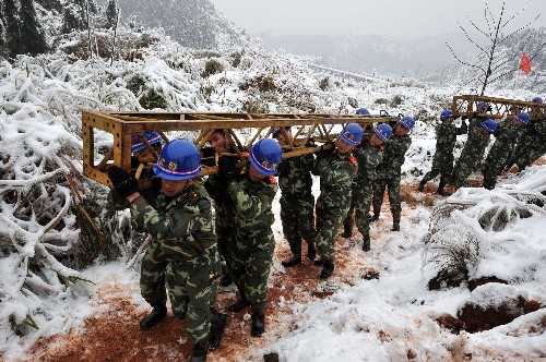 2月4日,武警水電二總隊(duì)五支隊(duì)官兵將抱桿搬運(yùn)上山。 由于受連續(xù)冰凍天氣影響,江西撫州市電網(wǎng)遭遇有史以來最嚴(yán)重的覆冰災(zāi)害,電網(wǎng)線路如同裹了一層厚厚的糨糊,最大電線結(jié)冰直徑達(dá)4厘米。江西臨川至建昌(臨川區(qū)滕橋村段)220千伏供電線路因凍雪重量的影響,造成線路繃斷,101、105號(hào)鐵塔和104號(hào)電線桿倒塌,造成撫州市南部的南城、南豐、資溪、宜黃、黎川、廣昌等6縣供電全部中斷已達(dá)10天,嚴(yán)重影響六縣180多萬群眾的生產(chǎn)生活。 災(zāi)情就是命令,武警水電二總隊(duì)發(fā)揮專業(yè)優(yōu)勢(shì),迅速出動(dòng)170余名官兵趕赴救災(zāi)現(xiàn)場(chǎng),眾志成城抗冰搶險(xiǎn),確保撫州市南部6縣180多萬群眾的生產(chǎn)生活用電。 新華社記者 宋振平 攝