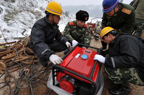 2月4日,武警水電二總隊(duì)五支隊(duì)官兵在搶修現(xiàn)場(chǎng)安裝汽油發(fā)電機(jī)。 新華社記者 宋振平 攝