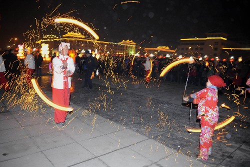 2月20日,太原市晉源區(qū)東街村“晉陽(yáng)風(fēng)火流星”表演隊(duì)72歲的聶連富和9歲的韓佳悅在廣場(chǎng)表演。 新華社記者 彭洋 攝