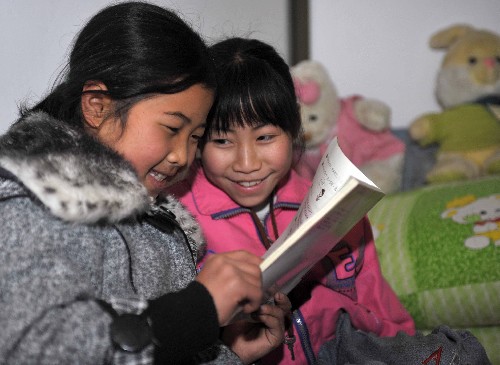 2月25日,在廣西興安縣縣城柘園小學,孤兒喻燕(左)和楊麗在翻看新發(fā)的課本。 當日,廣西桂林市興安縣柘園小學83名孤兒小學生全部順利返校,開始新學期校園生活。1月12日以來,廣西桂林市興安縣遭受50年一遇的冰雪災害,當?shù)卣朔刂乩щy,確保學生順利返校上課。目前,小學部分83名孤兒全部順利返校上課。 新華社記者 周華 攝