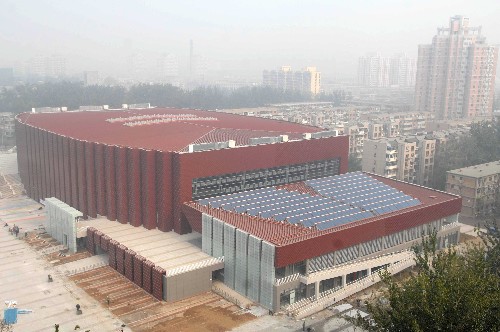 北京科技大學(xué)體育館外景(2007年11月7日拍攝)。 2008年奧運(yùn)會(huì)柔道和跆拳道比賽館――北京科技大學(xué)體育館,是北京奧運(yùn)會(huì)新建場(chǎng)館,被稱為一座“不用電力的體育館”,場(chǎng)館內(nèi)采用光導(dǎo)管照明系統(tǒng),安裝了148個(gè)光導(dǎo)管,通過(guò)采光罩高效采集室外自然光線并導(dǎo)入系統(tǒng)內(nèi)重新分配,經(jīng)過(guò)特殊制作的光導(dǎo)管傳輸和強(qiáng)化后,由系統(tǒng)底部的漫射器把自然光均勻高效地照射到場(chǎng)館內(nèi)部,從而打破了“照明完全依靠電力”的觀念。 新華社發(fā)
