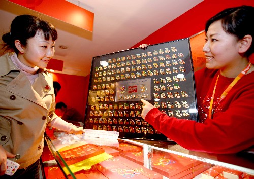 2月28日,一位工作人員(右)在向收藏愛好者介紹展出的漢城奧運(yùn)會(huì)紀(jì)念章?!⌒氯A社記者 陳建力 攝