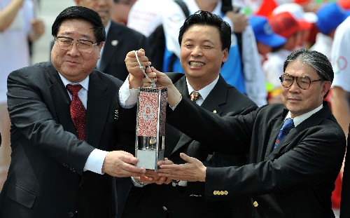 4月30日,北京奧組委執(zhí)行副主席楊樹安(中)、中央人民政府駐港聯(lián)絡辦公室主任高祀仁(左)和中國香港體育協(xié)會暨奧林匹克委員會會長霍震霆共同舉起火種燈展示。當日,搭載著2008年北京奧運圣火的專機飛抵中國香港。 新華社記者 呂小煒 攝