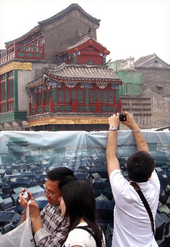 5月2日,市民在臨時(shí)圍墻外用相機(jī)拍攝前門大街街景。 新華社記者 王頌 攝