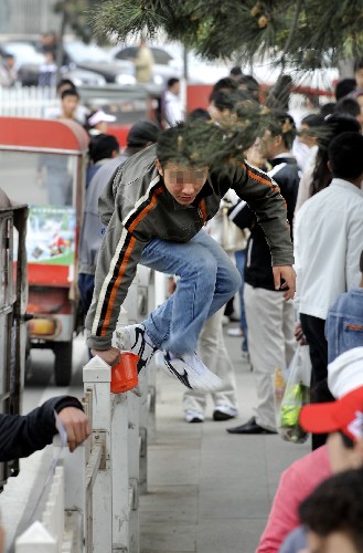 5月2日,一個(gè)青年在青島街道上“飛身跨欄”。 新華社記者 李紫恒 攝