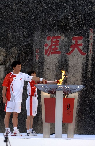 5月4日,最后一棒火炬手成龍(左)和蒲慧芳在天涯海角共同點燃圣火盆。當日,北京奧運會圣火傳遞活動在海南三亞舉行。 新華社記者 趙穎全 攝