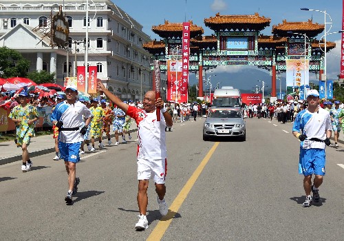 5月5日,火炬手鄭文泰在進(jìn)行傳遞。當(dāng)日,北京奧運會圣火傳遞活動在海南萬寧市舉行。 新華社記者 邢廣利 攝