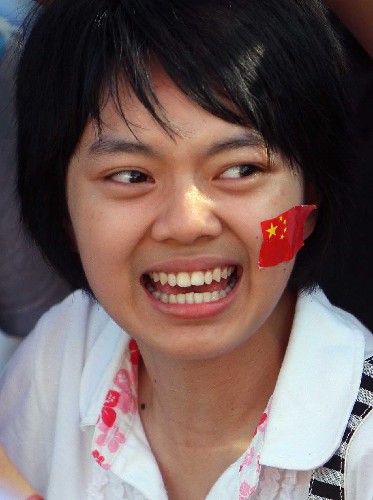 5月6日,一位女孩在路邊等候圣火的到來。當(dāng)日,北京奧運(yùn)圣火傳遞活動在海南省??谑信e行。 新華社記者 邢廣利 攝