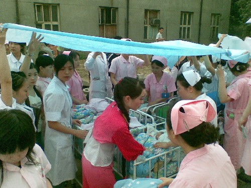 5月12日,在四川省人民醫(yī)院臨時護理集中點,醫(yī)護人員拉起一張布,為新生嬰兒建起臨時護理區(qū)。 當(dāng)日,四川汶川地震波及成都,四川省人民醫(yī)院的醫(yī)護人員緊急將病人轉(zhuǎn)移到安全地帶避險,積極搶救災(zāi)區(qū)傷員。 新華社發(fā)(魏德智 攝)