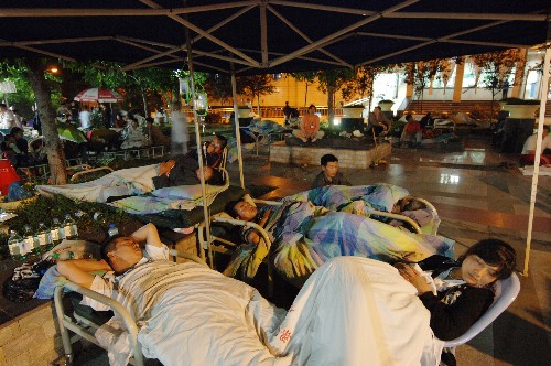5月12日深夜,在重慶市梁平縣人民醫(yī)院的空地上,幾名重病患者在臨時支起的雨棚下輸液、休息。 當(dāng)日,受四川汶川地震波及,重慶市梁平縣人民醫(yī)院為保護住院病人的人身安全和及時收治災(zāi)害中受傷人員,將上百名住院病人疏散至空曠地帶,同時搭起帳篷建立臨時醫(yī)療中心,維持醫(yī)院的正常運營。 新華社記者 劉潺 攝