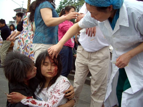 5月12日,受傷群眾在都江堰景區(qū)門口接受治療。 當(dāng)日,受地震影響,離汶川約100公里的四川省都江堰市部分設(shè)施受損,多處建筑坍塌,當(dāng)?shù)卣﹂_展救援工作。 新華社記者 鄭悅 攝