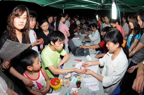 5月13日凌晨,眾多南充市民在街頭準(zhǔn)備為地震災(zāi)區(qū)傷員獻(xiàn)血。 當(dāng)日凌晨,四川南充市民紛紛來(lái)到紅十字中心血站設(shè)立在街頭的采血點(diǎn),踴躍為地震災(zāi)區(qū)傷員獻(xiàn)血。 新華社發(fā)(成潮生 攝)