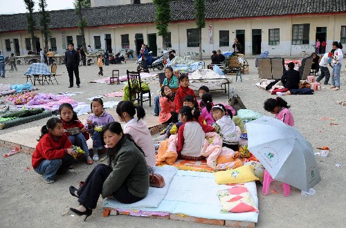 5月13日,陜西寧強縣南街小學(xué)師生在操揚上躲避可能發(fā)生的余震。 陜西省寧強縣地處川陜交界處,是汶川地震陜西受災(zāi)最重的縣之一。據(jù)初步統(tǒng)計,寧強縣在地震中共有5人死亡,上百人受傷,倒塌房屋5000余間,另有7萬多間房屋裂損嚴重。 新華社記者 陶明 攝