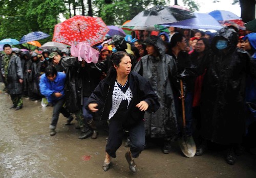 5月13日,一名等待孩子消息的家長看到一名遇難學(xué)生的遺體被抬出后,奮力向前沖去。當(dāng)天,救援人員繼續(xù)在四川都江堰市聚源鎮(zhèn)聚源中學(xué)冒雨進行救援工作,雖然地震造成大量傷亡,但仍有跡象表明廢墟中有幸存者。 新華社記者 王建華 攝