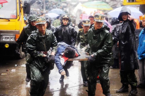5月13日,救援人員在聚源中學(xué)將一名剛剛從廢墟中找到的遇難學(xué)生遺體抬離現(xiàn)場。當(dāng)天,救援人員繼續(xù)在四川都江堰市聚源鎮(zhèn)聚源中學(xué)冒雨進行救援工作,雖然地震造成大量傷亡,但仍有跡象表明廢墟中有幸存者。 新華社記者 王建華 攝