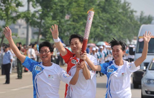 5月13日,火炬手劉學(xué)軍(中)與護(hù)跑手馮海濤(左)、廖惠娟一起傳遞。當(dāng)日,北京奧運(yùn)圣火傳遞活動在福建省龍巖市舉行。 新華社記者 張國俊 攝