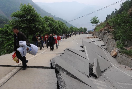 這是群眾從四川省北川縣縣城邊受損嚴(yán)重的公路上撤離(5月13日攝)。 記者從四川省綿陽(yáng)市抗震救災(zāi)指揮部了解到,受災(zāi)特別嚴(yán)重的北川縣老縣城80%、新縣城60%以上的建筑物因地震垮塌,縣城周邊發(fā)生大面積山體滑坡。 新華社記者 陳燮 攝