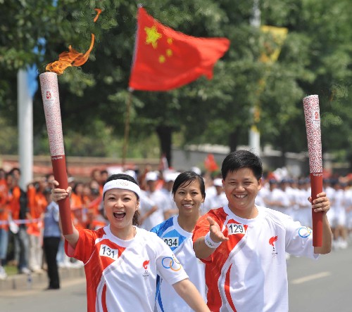 5月13日,火炬手袁鳴(左)與上一棒火炬手謝海波交接后,開始傳遞。當(dāng)日,北京奧運(yùn)圣火傳遞活動在福建省龍巖市舉行。新華社記 張國俊 攝