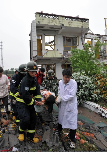 5月13日,救護(hù)人員把被救出的學(xué)生抬往醫(yī)院。 四川綿竹市漢旺鎮(zhèn)武都小學(xué)的教學(xué)樓在地震中倒塌,眾多師生被埋在倒塌的校舍中。救援行動(dòng)正在積極展開(kāi)。 新華社記者 何俊昌 攝
